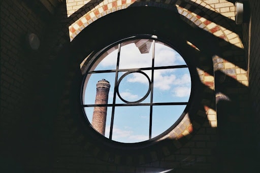 A decorative glass window panel with a tower in its view.