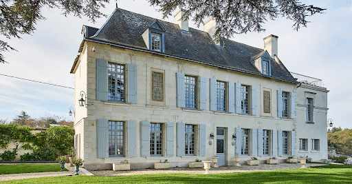 An image of a large, vintage manor with custom luxury glass French windows that match the traditional architecture.